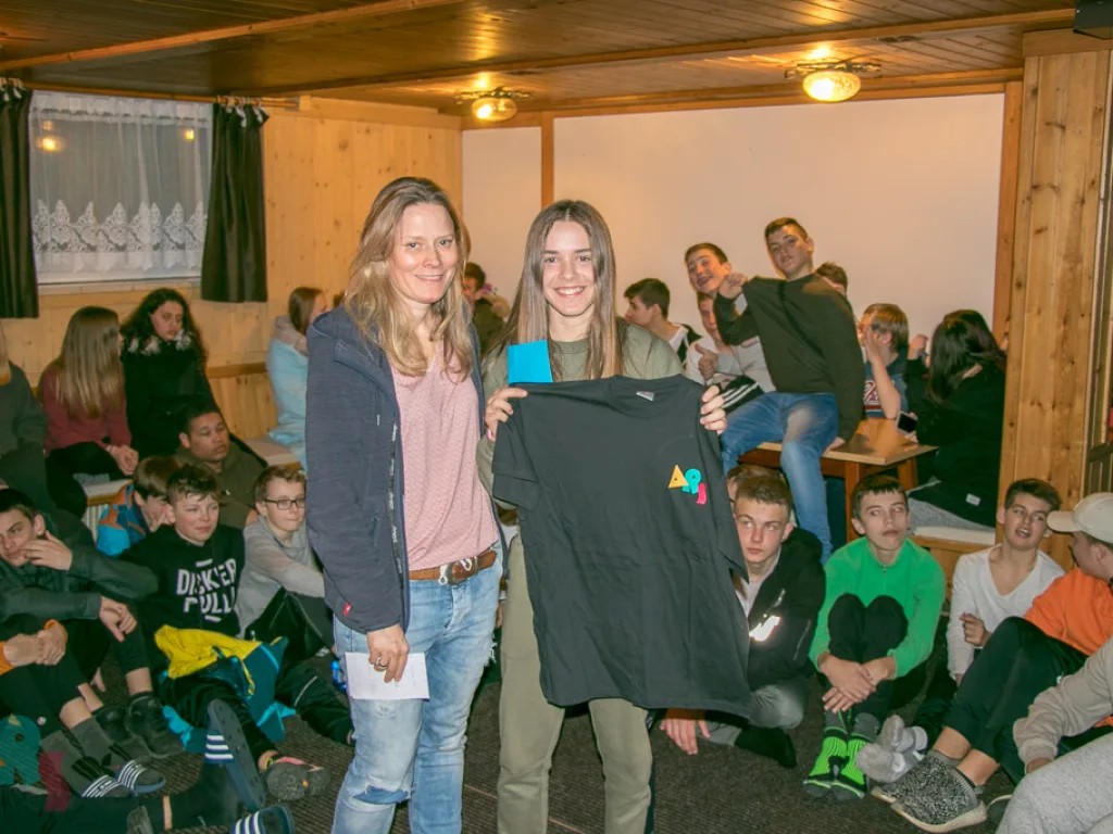 Zwei Personen halten einen bedruckten Pullover hoch.